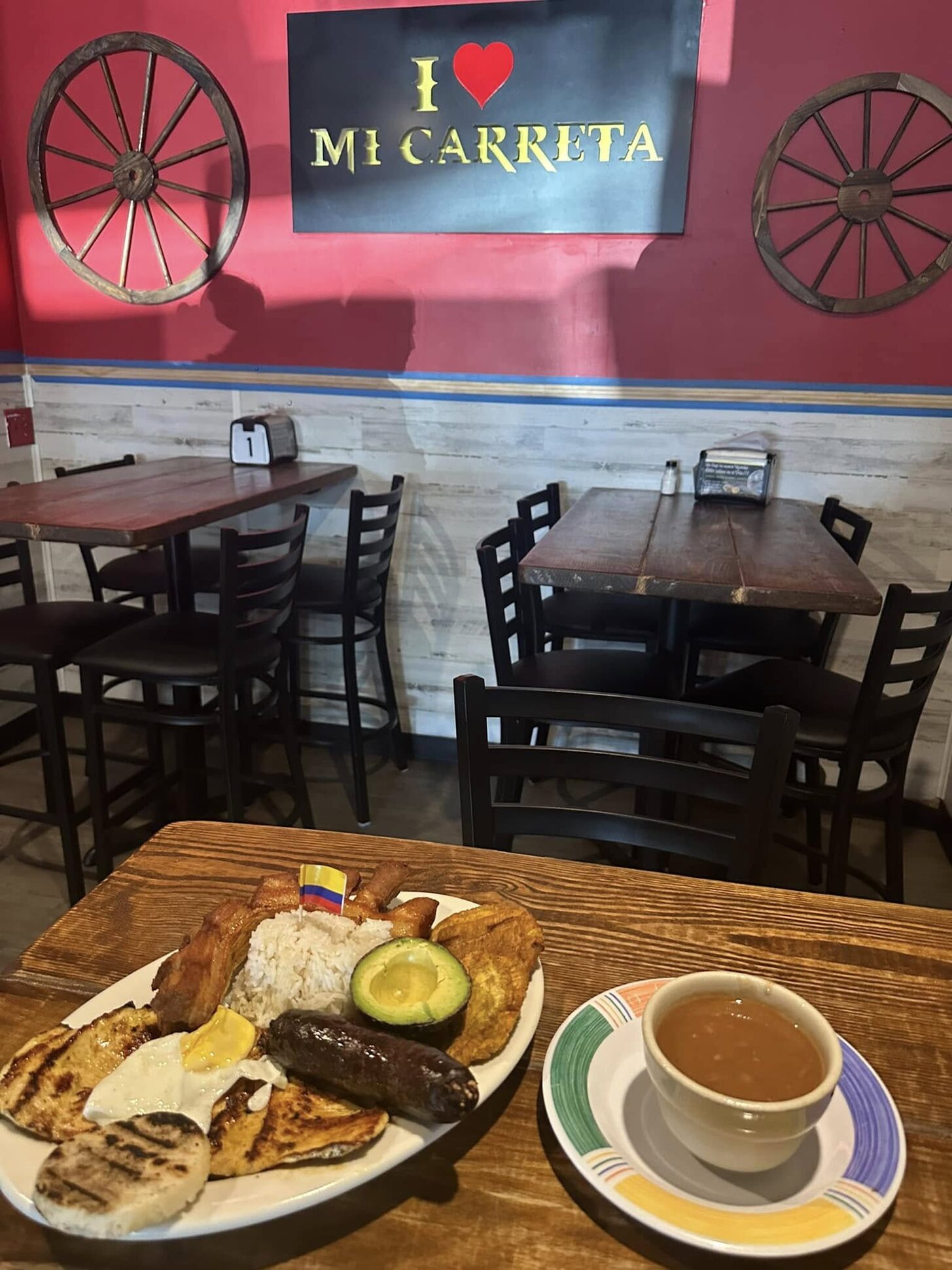 A breakfast plate and a cup of hot chocolate on a wooden table in the dining room