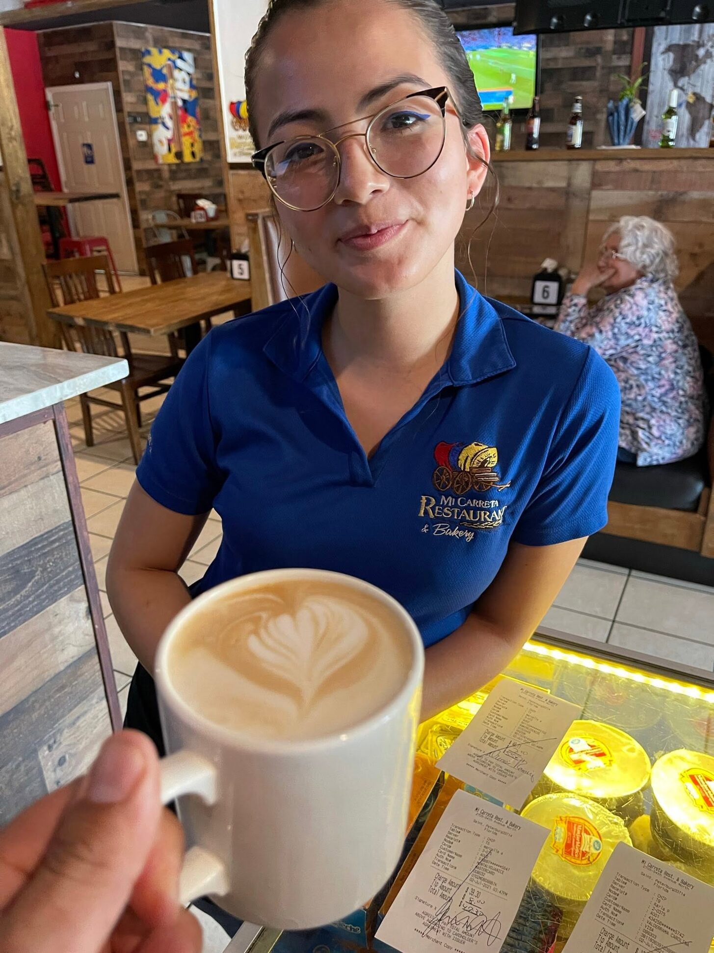 A Mi Carreta barista holding out a latte