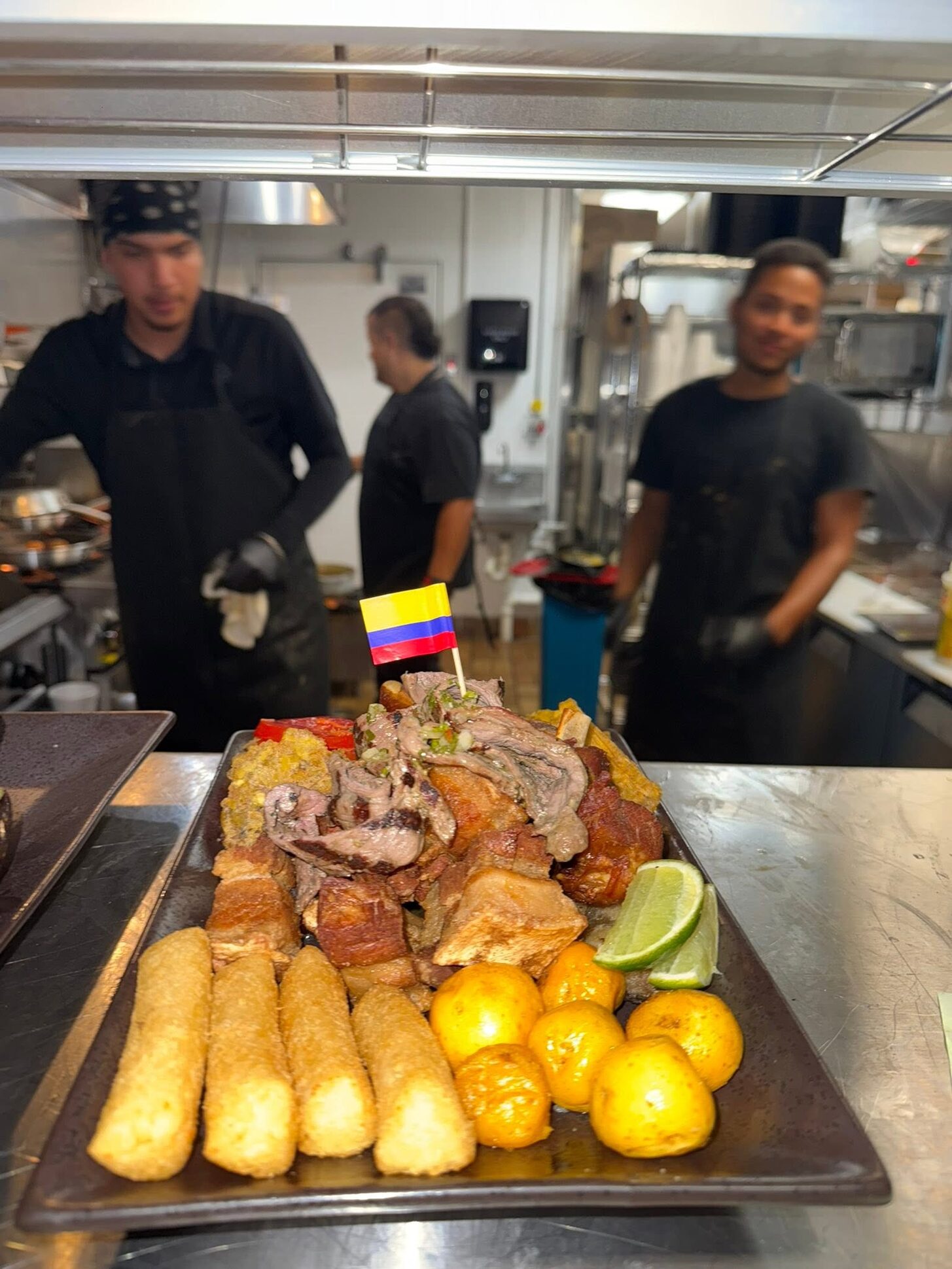 A picada tray with yuca, papa criolla and roast pork at the kitchen pass
