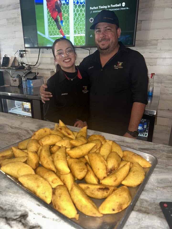 Two Mi Carreta team members with a big tray of empanadas