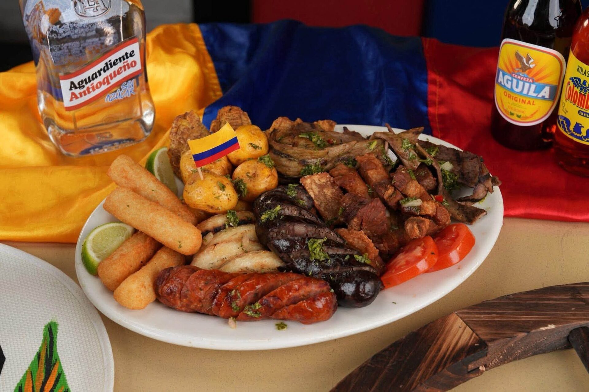 A picada of chorizo, chicharrón, yuca and steak with aguardiente on the table