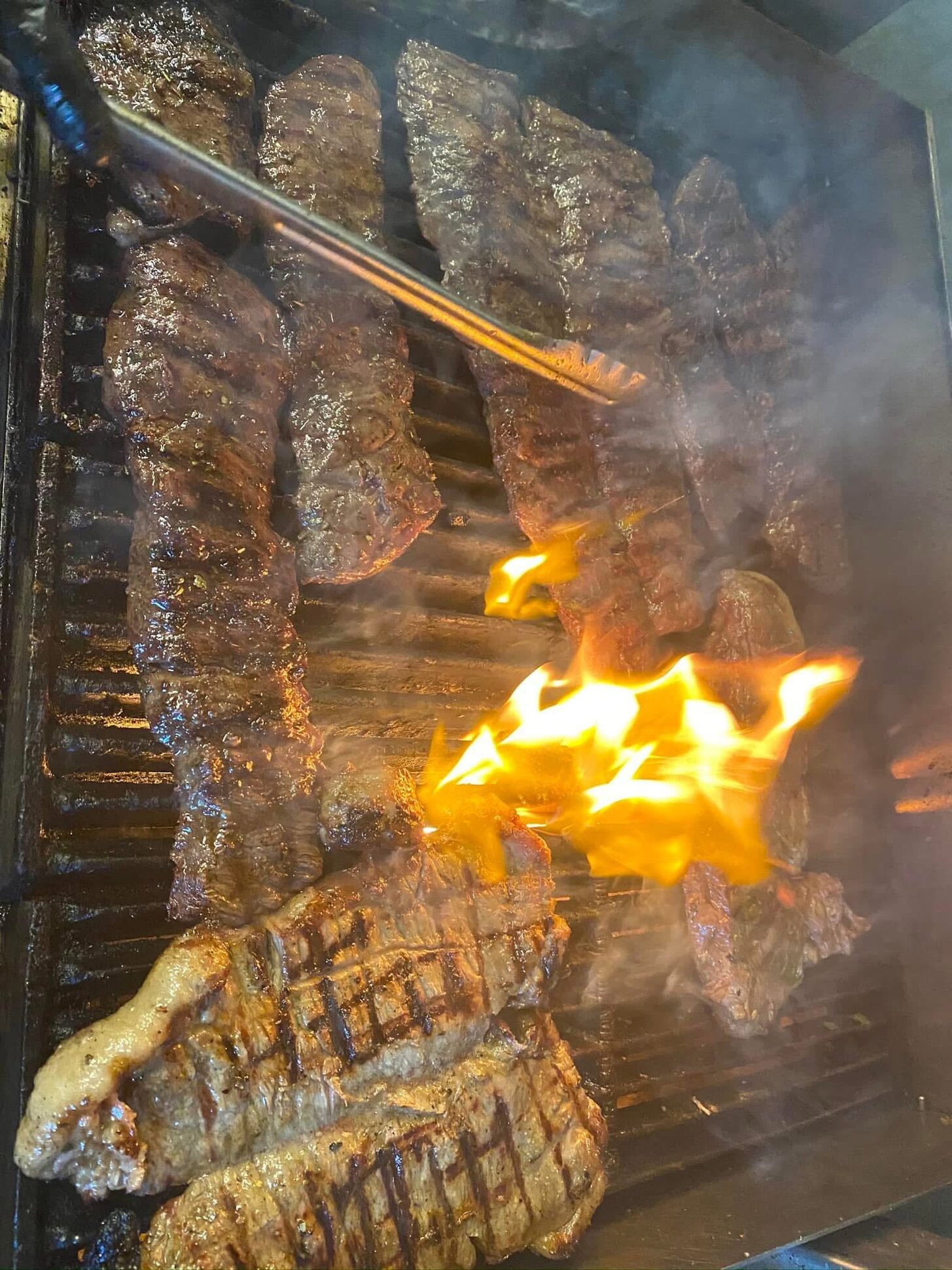 Skirt steak and chicken over open flame on the grill