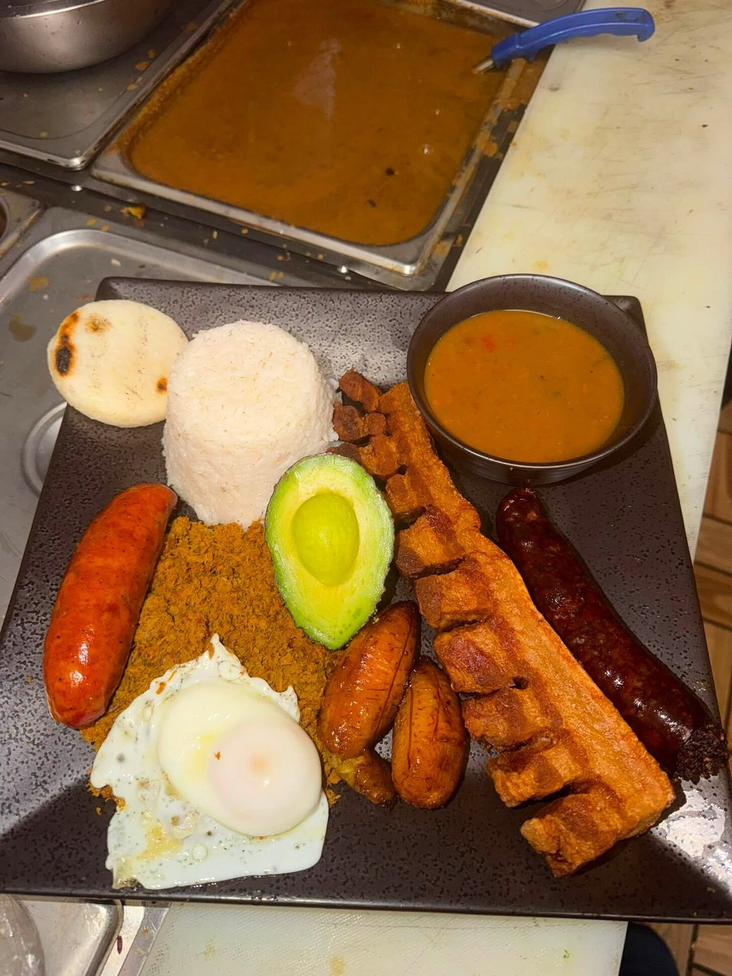 Bandeja paisa: chicharrón, chorizo, morcilla, fried egg, avocado, ground beef, rice, arepa and plantains