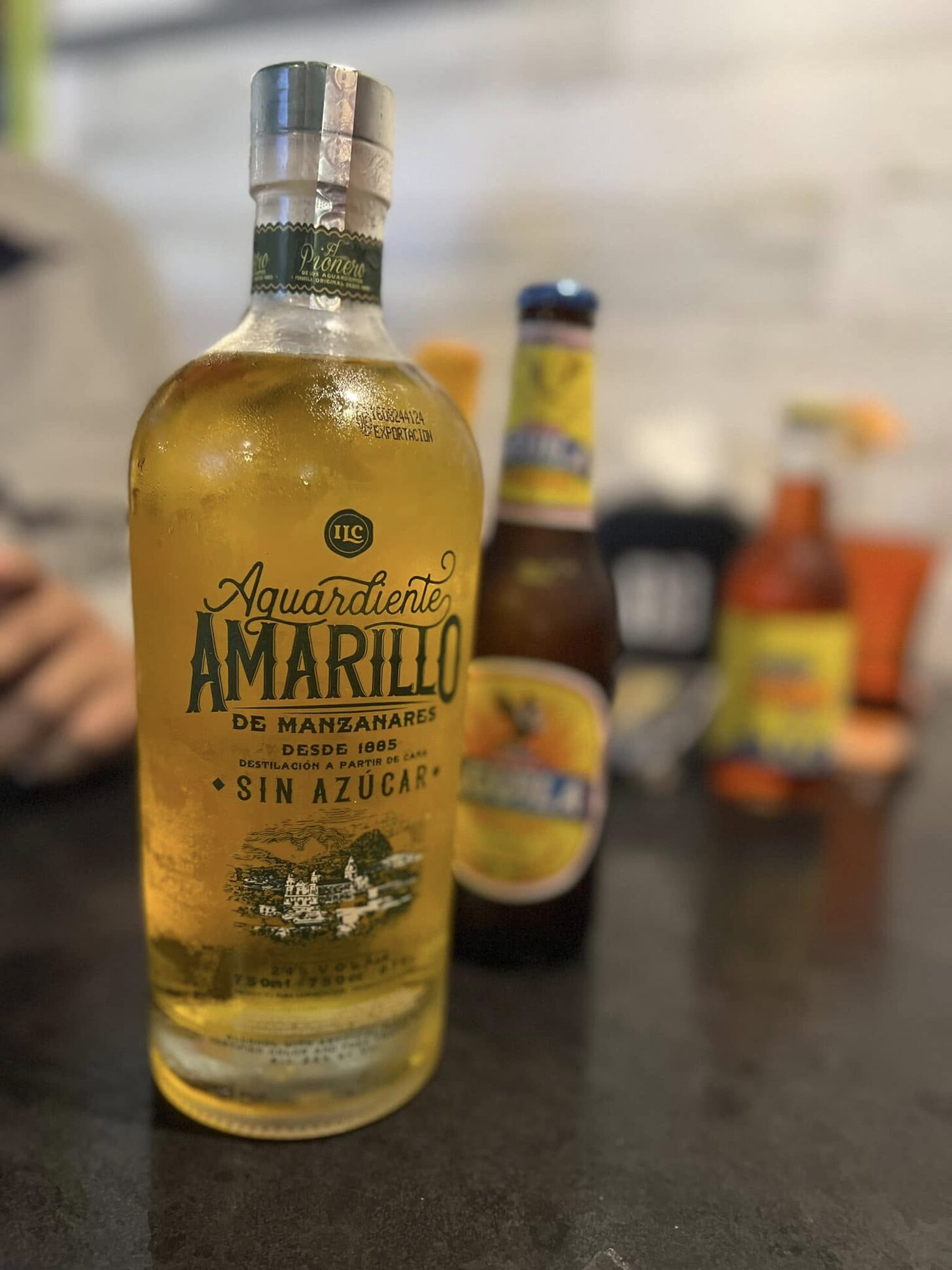 A bottle of Aguardiente Amarillo with a beer