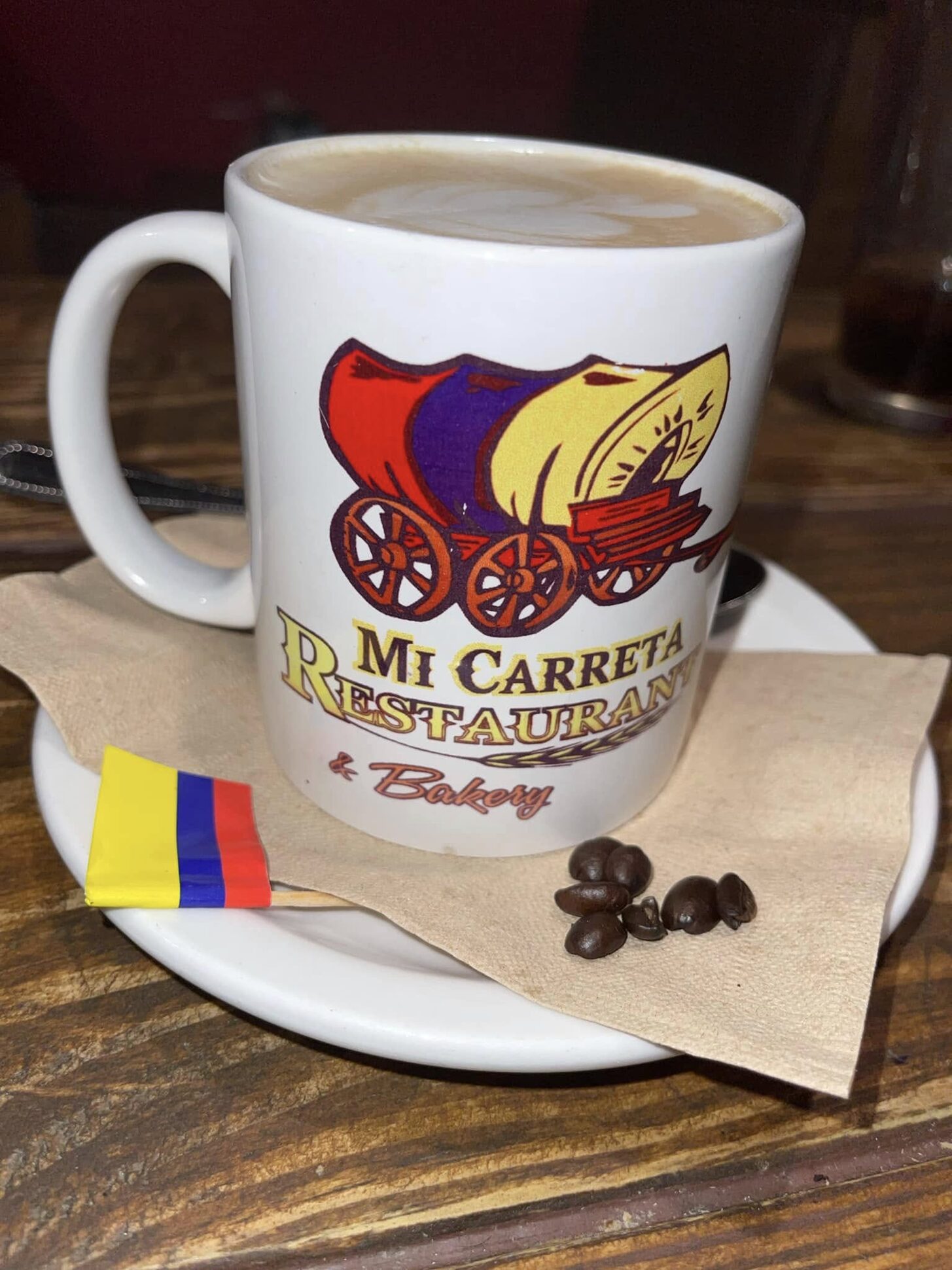 Café con leche in a Mi Carreta mug with a Colombian flag napkin
