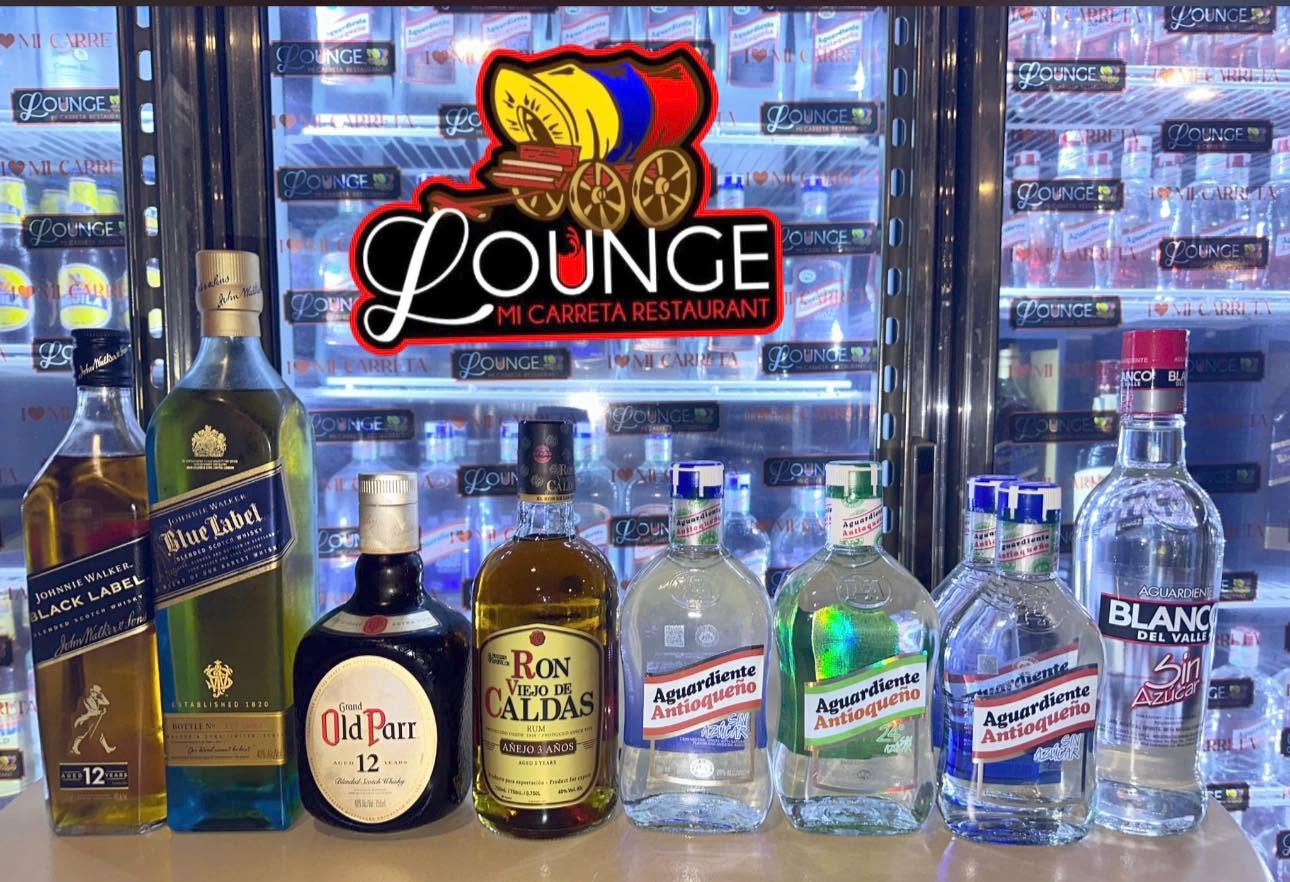 Bottles lined up under the illuminated Lounge sign